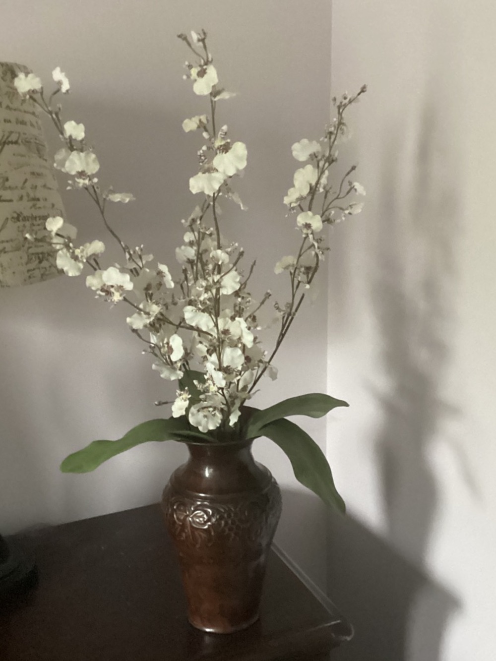 Decorative hammered metal vase with faux orchid